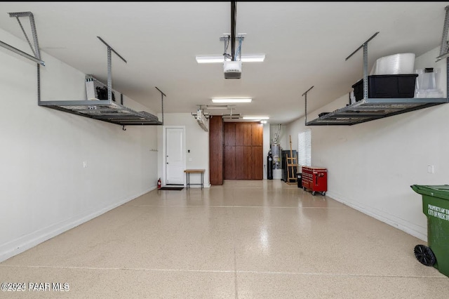 garage featuring a garage door opener and water heater