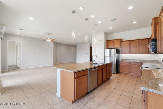 kitchen featuring brown cabinets, recessed lighting, a ceiling fan, appliances with stainless steel finishes, and a sink