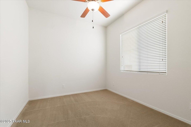 unfurnished room featuring a ceiling fan, light carpet, and baseboards