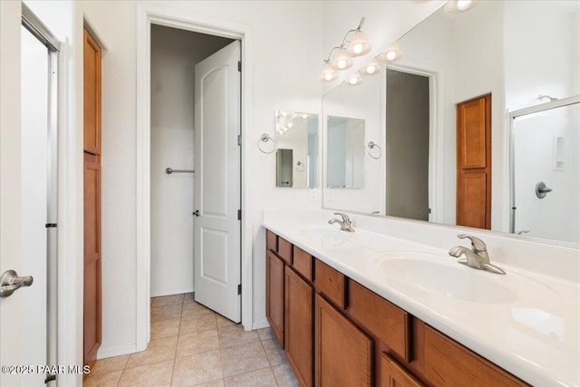 full bathroom featuring tile patterned floors, a sink, double vanity, and a shower with shower door