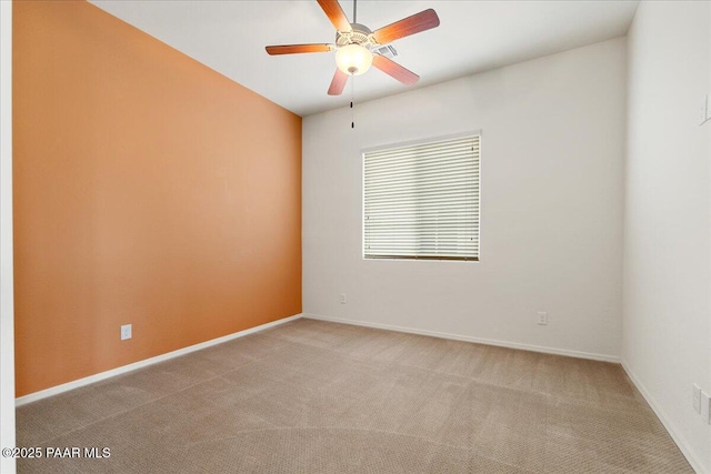 carpeted empty room featuring baseboards and ceiling fan