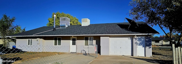 view of front facade featuring central AC unit and a garage