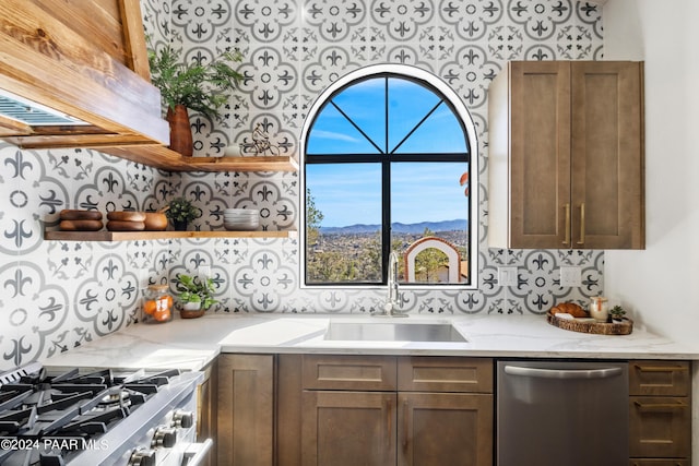 kitchen featuring a mountain view, plenty of natural light, stainless steel appliances, and light stone counters