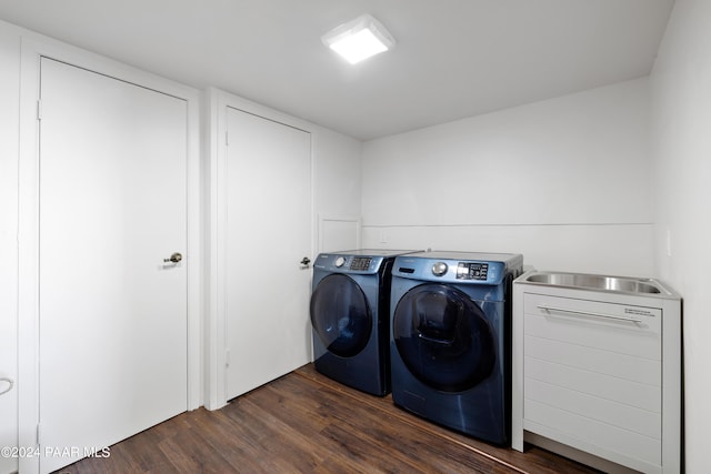 washroom featuring dark hardwood / wood-style flooring, washer and dryer, and sink