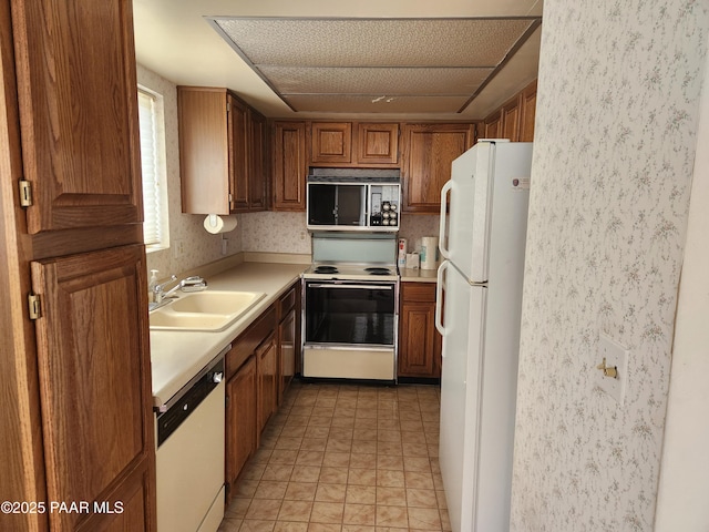 333 W Leroux St Unit F2, Prescott, AZ 86303 - kitchen featuring white appliances, brown cabinetry, light tile patterned flooring, a sink, and light countertops