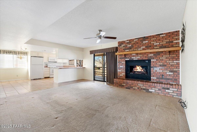 unfurnished living room with light tile patterned floors, a ceiling fan, light carpet, a textured ceiling, and a brick fireplace