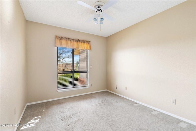 carpeted empty room featuring a textured ceiling, baseboards, and ceiling fan