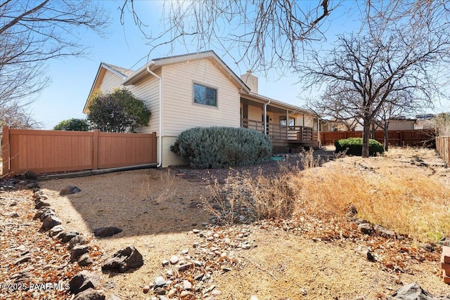 view of side of property featuring fence and a chimney