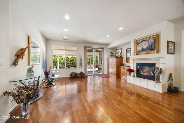 living room featuring a tile fireplace and hardwood / wood-style flooring