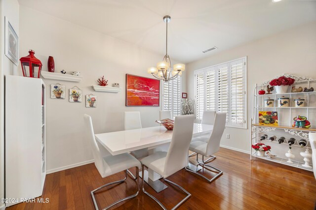 dining area with an inviting chandelier and hardwood / wood-style flooring