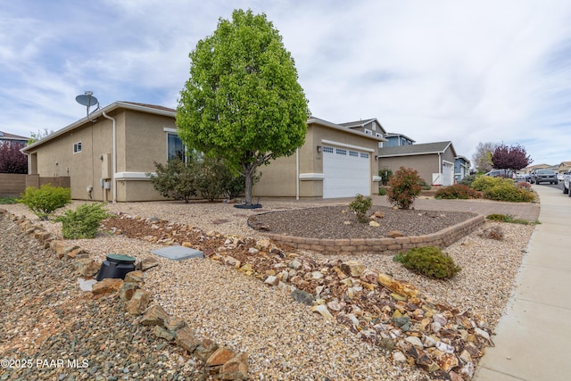 view of front of house featuring an attached garage, driveway, stucco siding, and fence
