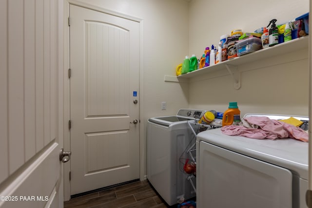 washroom featuring dark wood-style flooring, washer and clothes dryer, and laundry area