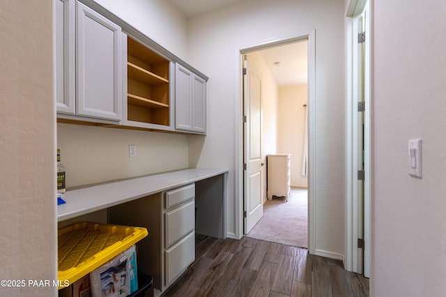 unfurnished office with dark wood-type flooring and built in study area