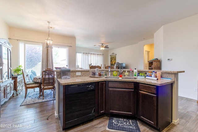 kitchen with light wood-style floors, dark brown cabinets, dishwasher, and a sink