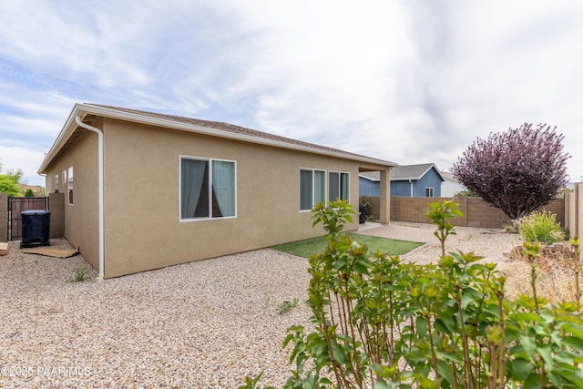 back of property with stucco siding, a fenced backyard, and a patio area