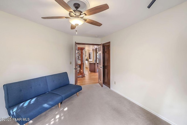 sitting room featuring light colored carpet and ceiling fan