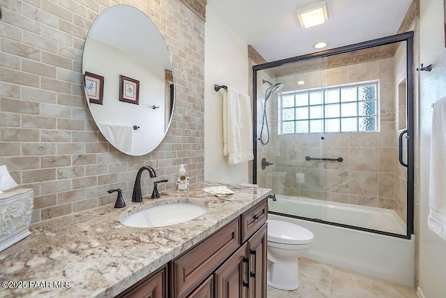 full bathroom with tile patterned floors, toilet, combined bath / shower with glass door, tasteful backsplash, and vanity