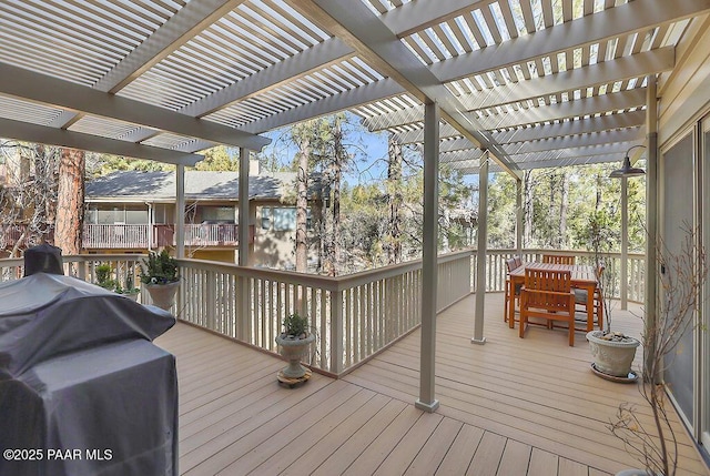 wooden deck featuring area for grilling and a pergola