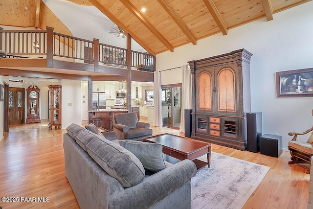 living room featuring high vaulted ceiling, light hardwood / wood-style flooring, wooden ceiling, and beamed ceiling