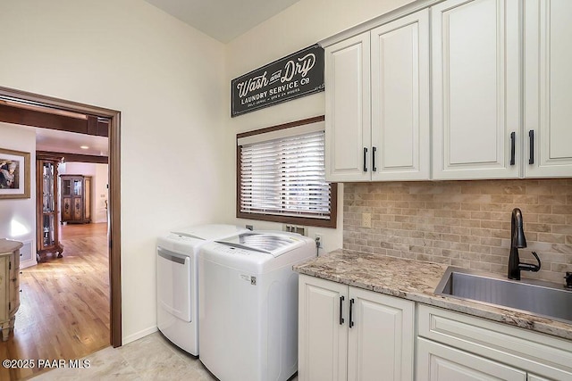 washroom featuring separate washer and dryer, sink, and cabinets