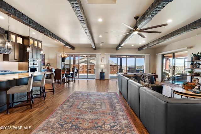 living room with dark hardwood / wood-style flooring, beam ceiling, and a wealth of natural light