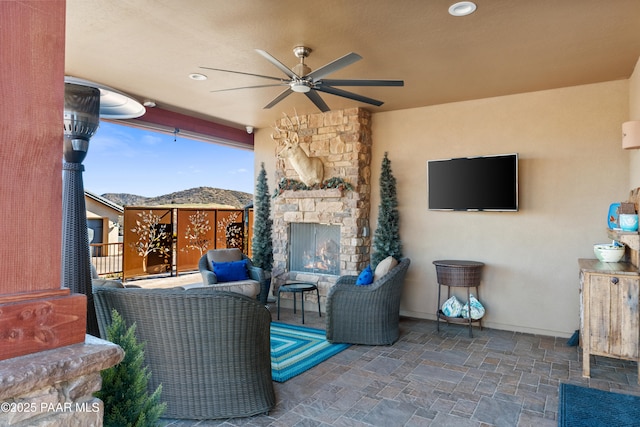 view of patio / terrace featuring ceiling fan and an outdoor stone fireplace