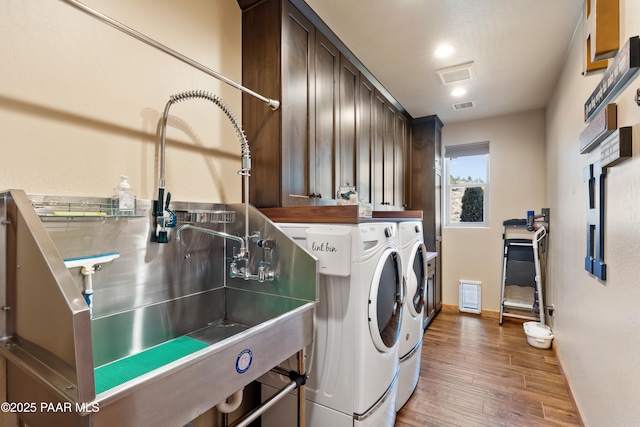 clothes washing area with sink, dark hardwood / wood-style floors, and washer and dryer