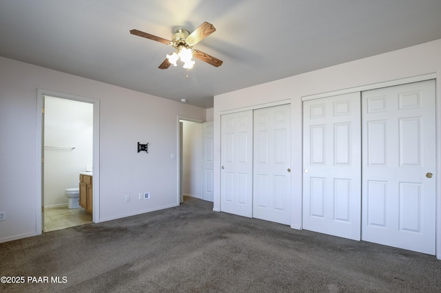 unfurnished bedroom featuring ceiling fan, carpet floors, two closets, and ensuite bath