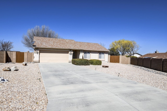 ranch-style house with driveway, an attached garage, and fence