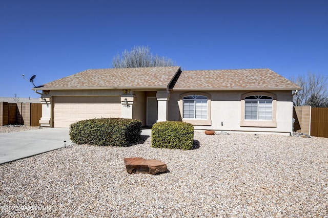 ranch-style house with stucco siding, a garage, concrete driveway, and fence