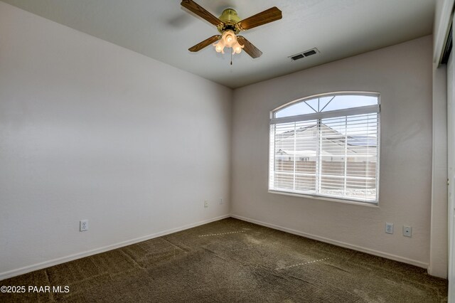 spare room featuring carpet flooring, baseboards, visible vents, and ceiling fan