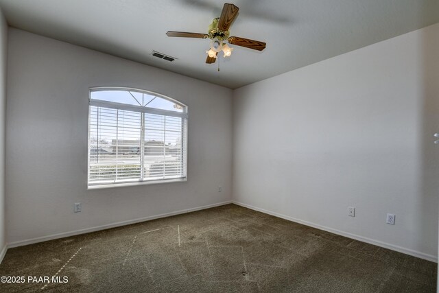 spare room featuring visible vents, baseboards, a ceiling fan, and carpet flooring