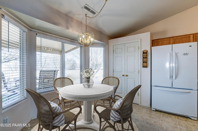 dining area featuring light tile patterned floors, visible vents, an inviting chandelier, and lofted ceiling