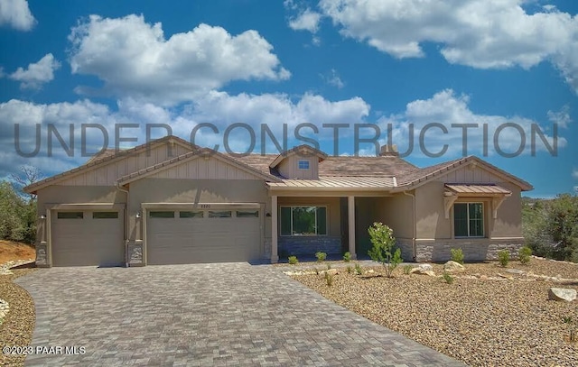 12345 N Petra Cir, Prescott, AZ 86305 - view of front facade with stone siding, an attached garage, decorative driveway, a standing seam roof, and stucco siding