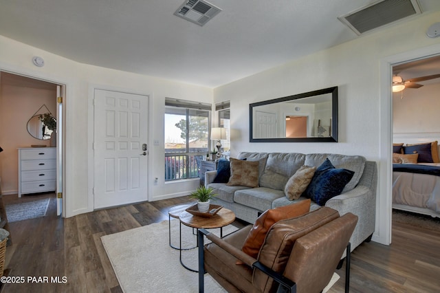 living area featuring wood finished floors, baseboards, and a ceiling fan
