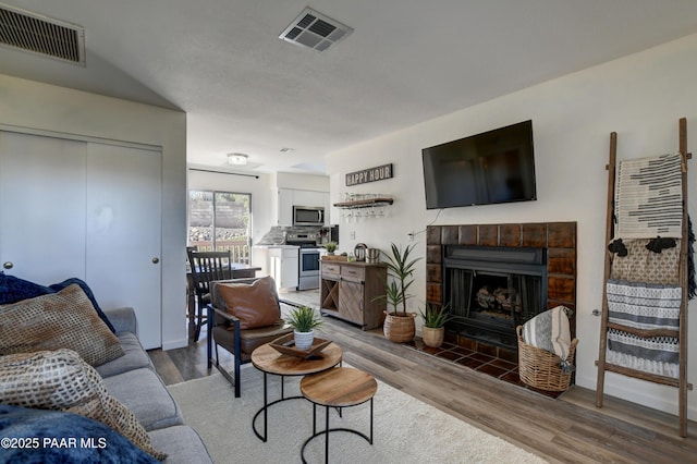 living room with wood finished floors and a fireplace with flush hearth