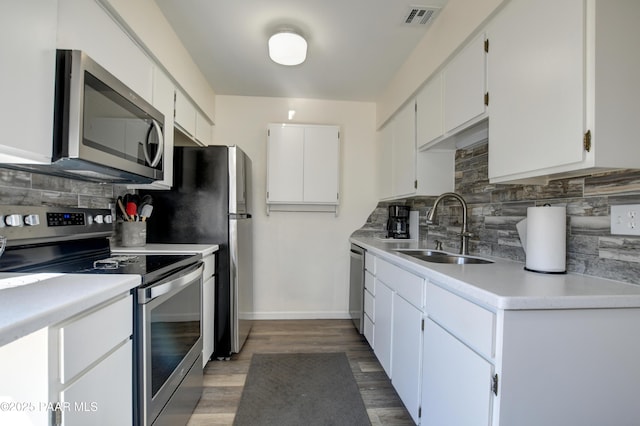 kitchen featuring stainless steel appliances, a sink, backsplash, and light countertops