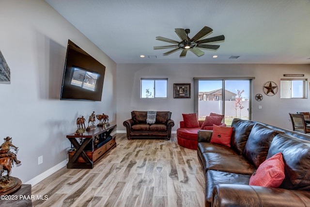 living room with light hardwood / wood-style floors and ceiling fan