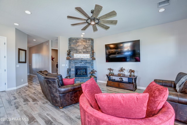 living room with ceiling fan, a fireplace, and hardwood / wood-style flooring