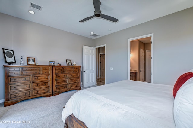 carpeted bedroom with ensuite bath and ceiling fan