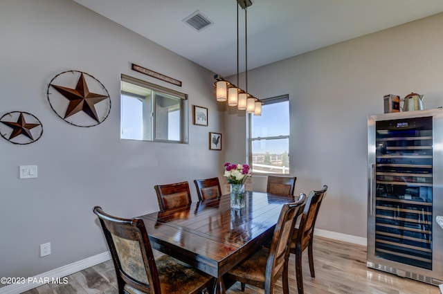 dining space featuring wood-type flooring and wine cooler