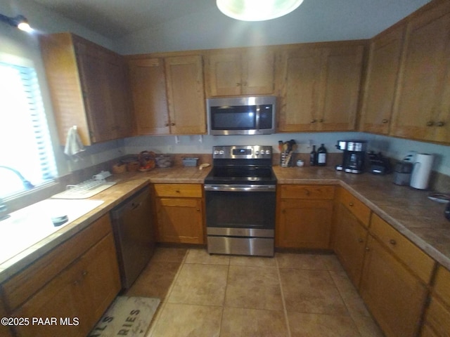 kitchen with stainless steel appliances, sink, and light tile patterned floors