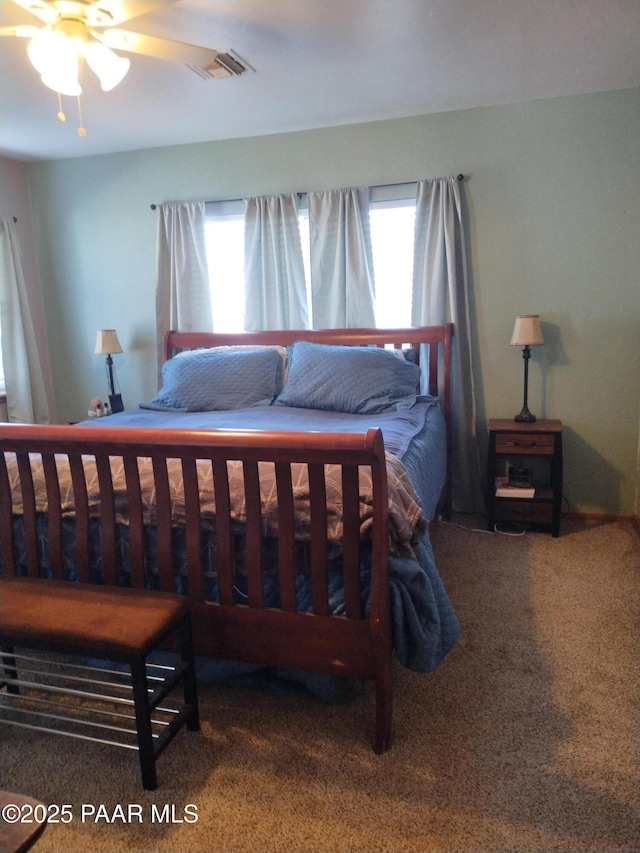 carpeted bedroom with multiple windows and ceiling fan