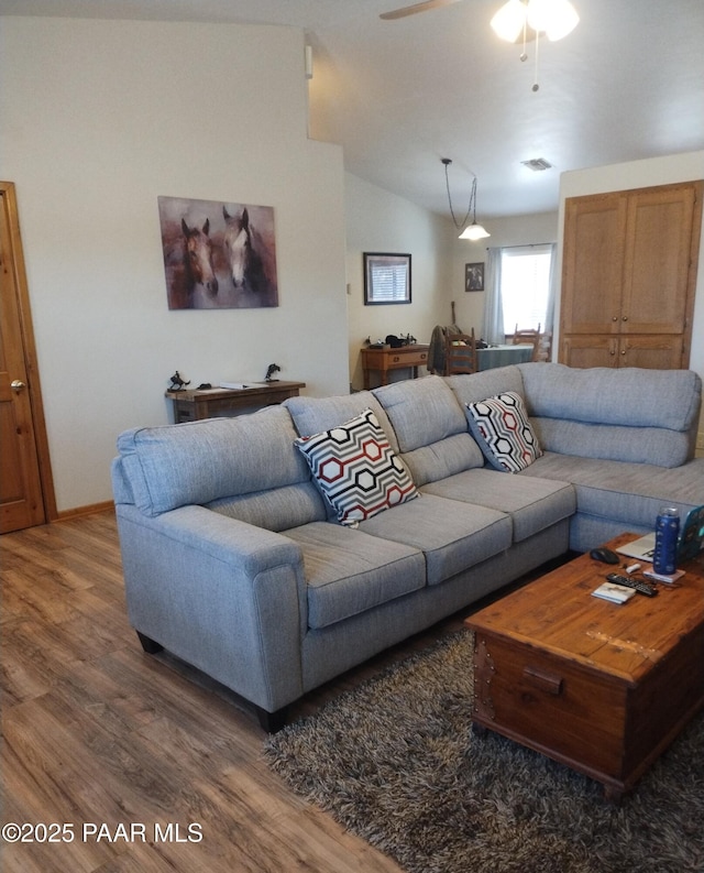 living room featuring hardwood / wood-style floors, vaulted ceiling, and ceiling fan