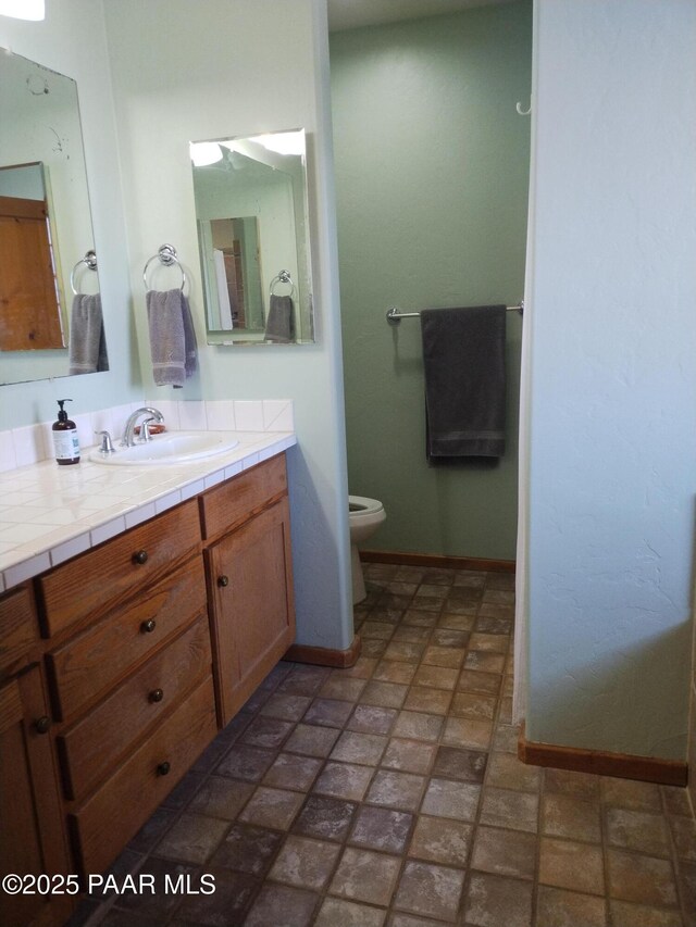 carpeted bedroom featuring connected bathroom, a walk in closet, a closet, and ceiling fan