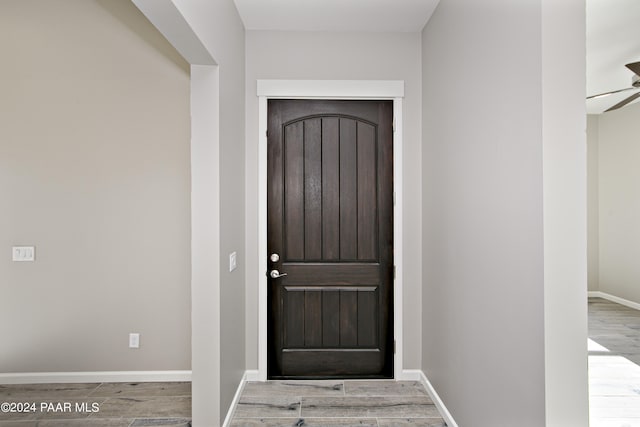 entryway featuring baseboards, wood finished floors, and ceiling fan