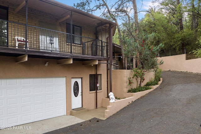 4937 S Deer Trl, Prescott, AZ 86303 - view of property exterior with a balcony, stucco siding, an attached garage, and driveway