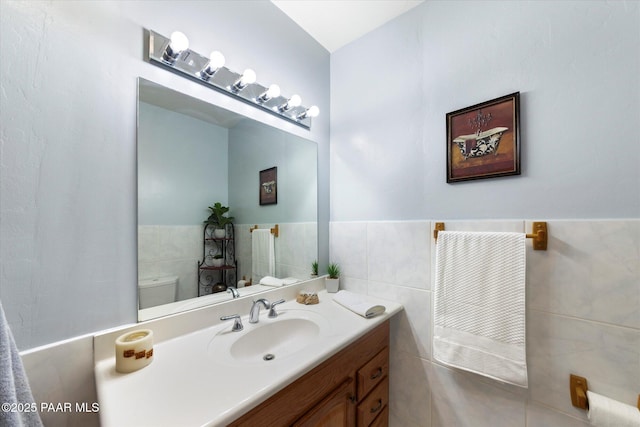 4937 S Deer Trl, Prescott, AZ 86303 - half bathroom with toilet, tile walls, vanity, and wainscoting