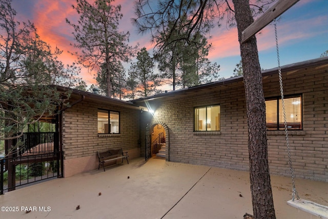 4937 S Deer Trl, Prescott, AZ 86303 - back of house at dusk with a patio area and brick siding