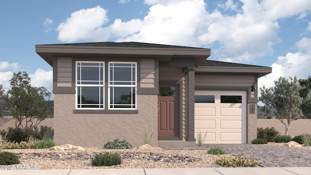 prairie-style house with a garage, stucco siding, and decorative driveway